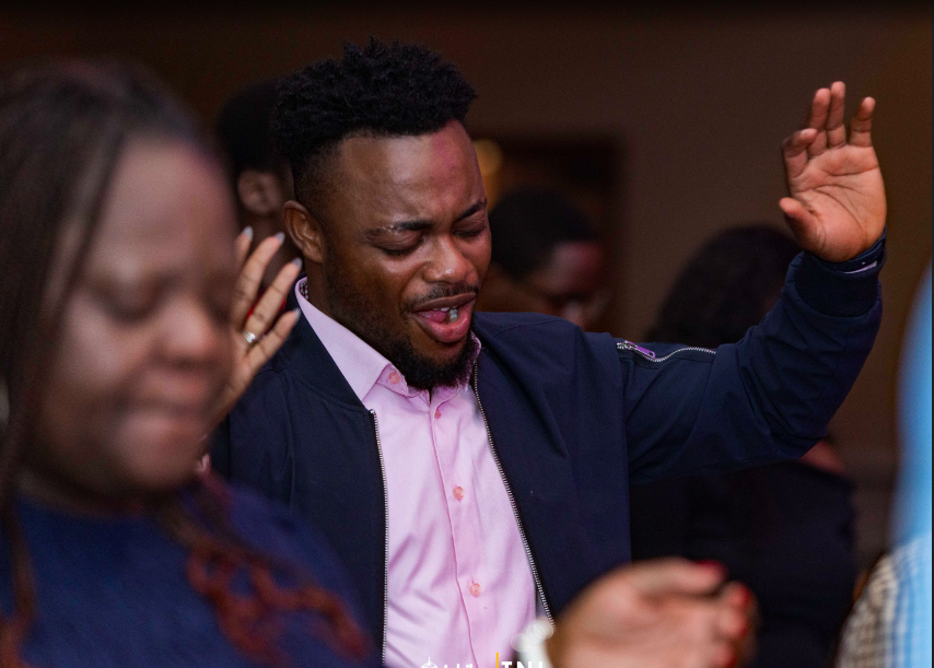 A man worshipping with his hand raised